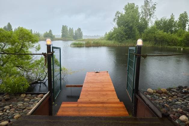 IMAGO Creative, Jahreszeit Sommer, Regen, Sommerregen Serene wooden dock beside calm water during a rainy day Saint Petersburg, Saint Petersburg, Russia R_KNCD251008-1849890-01