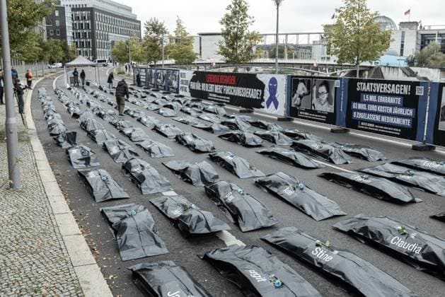 Protestaktion der Patientenorganisation Kinder ME CFS vorm Bundesministerium für Forschung, Technologie und Raumfahrt. Deutschland, Berlin am 15.10.2025: 100 Leichensäcke vor dem BMFTR als stille Visualisierung der humanitären Katastrophe (Zitat). Schwarzer Leichensack mit Vornamen und dem Banner im Hintergrund ME CFS, Long Covid, Post Vac: Lebendig begraben. Frau Bär: Wo bleibt Merz Forschungsdekade? *** Protest action by the patient organization Kinder ME CFS in front of the Federal Ministry of Research, Technology and Space Germany, Berlin on 15 10 2025 100 body bags in front of the BMFTR as a silent visualization of the humanitarian catastrophe Quote Black body bag with first names and the banner in the background ME CFS,