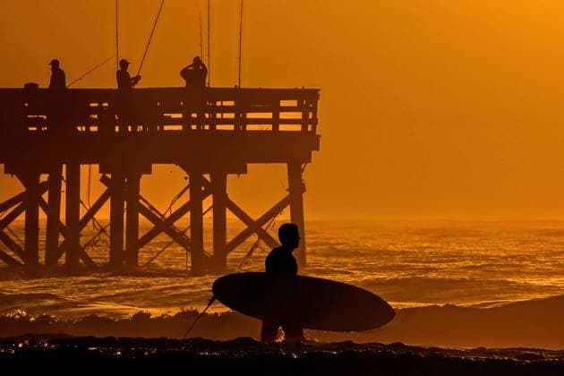 October 8, 2025, Isle Of Palms, Sc, United States: A surfer silhouetted by the sunrise over the Atlantic Ocean looks for the break along Front Beach, October 8, 2025 in Isle of Palms, South Carolina. Isle Of Palms United States - ZUMAe02_ 20251008_zaf_e02_001 Copyright: xRichardxEllisx