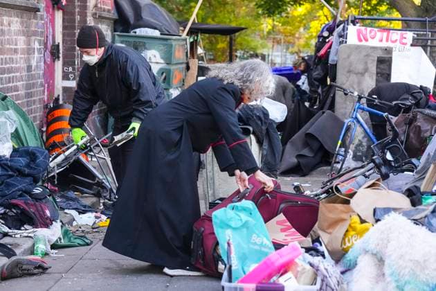 October 16, 2025, Toronto, On, Canada: Rev. Canon Maggie Helwig, centre, helps move a resident s belongings as Toronto city workers prepare to clear the unhoused persons encampment at St. Stephen-in-the-Fields Church, in Toronto, on Thursday, Oct. 16, 2025. Toronto Canada - ZUMAc35_ 20251016_zaf_c35_015 Copyright: xChrisxYoungx