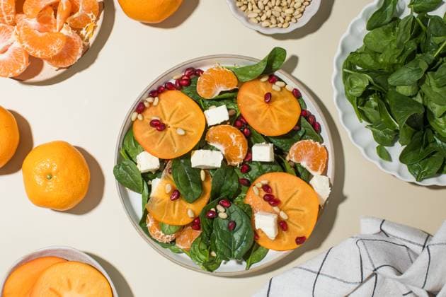 Winterlicher Salat. Frischer Kaki und Granatapfel-Spinat-Salat mit Feta und Pinienkernen Fresh persimmon and pomegranate spinach salad with feta and pine nuts. Concept of winter dish. (License=RF) Copyright: xZoonar.com ViktoriiaxPopovax 23941308