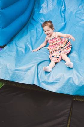 Toddler girl sliding on a bouncy castle, summer holiday Corby, England, United Kingdom R_ATMT250610E-1759498-01 ,model released, Symbolfoto