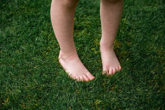 Little girl s bare feet on green grass in summer, copy space Corby, England, United Kingdom R_ATMT250630B-1773205-01 ,model released, Symbolfoto