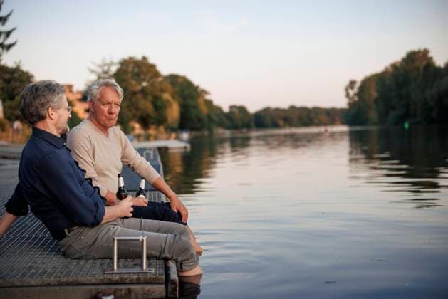 Senior friends sitting on pier with beer bottles near lake model released, Symbolfoto, JOSEF21713