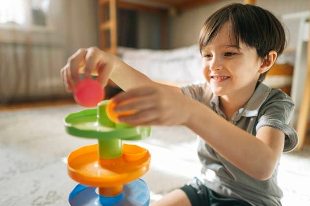 Boy playing with a colorful toy at home, focusing on development and education model released, Symbolfoto property released, ANAF04620