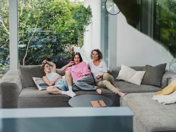 Family relaxing together on couch watching television in living room model released, Symbolfoto property released, MFF09736