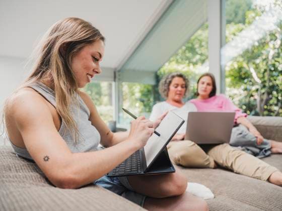 Mother and daughters planning together on couch with digital devices model released, Symbolfoto property released, MFF09761