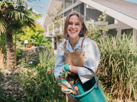 Smiling woman gardening outdoors with apron and bucket in summer model released, Symbolfoto property released, MFF09891