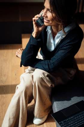 Businesswoman smiling on phone call in modern office with laptop model released, Symbolfoto property released, MOEF05010