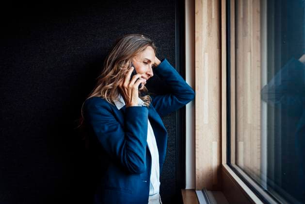 Businesswoman in blue suit talking on smartphone by office window model released, Symbolfoto property released, MOEF05083