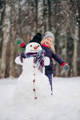 Smiling child with snowman playing outdoors in winter forest model released, Symbolfoto, NASF00027
