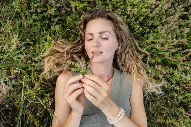 Woman with curly hair relaxing outdoors enjoying aromatherapy herbs model released, Symbolfoto, OSF02667