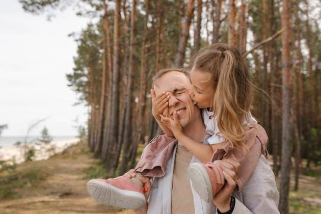 Father giving daughter a playful shoulder ride in a forest model released, Symbolfoto, VIVF01716
