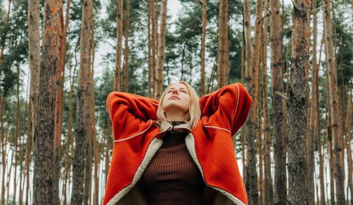 Woman relaxing in pine forest wearing warm jacket in autumn model released, Symbolfoto, VSNF04294