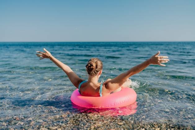 A woman is floating on a pink inflatable raft in the ocean A woman is floating on a pink inflatable raft in the ocean. She is smiling and she is enjoying herself, model released, , property released, , 60823270.jpg RECORD DATE NOT STATED