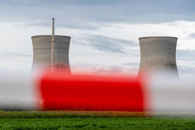 Gundremmingen, Bavaria, Germany - October 25, 2025: The nuclear power plant on the day the cooling towers of the decommissioned Gundremmingen nuclear power plant (AKW KRB) in Bavaria were blown up. The two 160-metre-high towers will be blown up at 12 noon on Saturday, October 25, 2025. Symbolic photo nuclear phase-out, barrier tape and warning beacon in the foreground, the nuclear power plant in the background *** Das Atomkraftwerk am Tag der Sprengung der Kühltürme des stillgelegten Kernkraftwerks Gundremmingen (AKW KRB) in Bayern. Die beiden 160 Meter hohen Türme werden am Samstag, 25. Oktober 2025, um 12 Uhr gesprengt. Symbolfoto Atomausstieg, Absperrband bzw Warnbake im Vordergrund, im Hintergrund das AKW