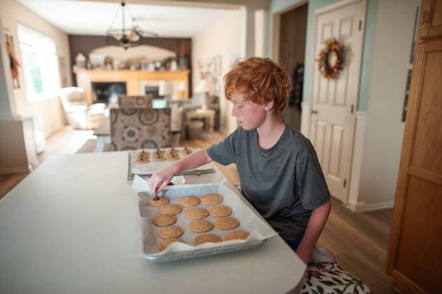 Young boy baking fresh cookies at home in cozy kitchen setting Grimes, Iowa, United States CR_LIPF251023-1869051-01 ,model released, Symbolfoto