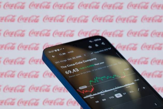 Coca Cola Company - Photo Illustration The Coca-Cola Company stock price is displayed on a mobile phone with the company s branding seen in the background in this photo illustration in Brussels, Belgium, on October 27, 2025. (Photo Illustration by Jonathan Raa NurPhoto) Brussels Belgium  Copyright: xJonathanxRaax originalFilename: raa-cocacola251027_np3EM.jpg