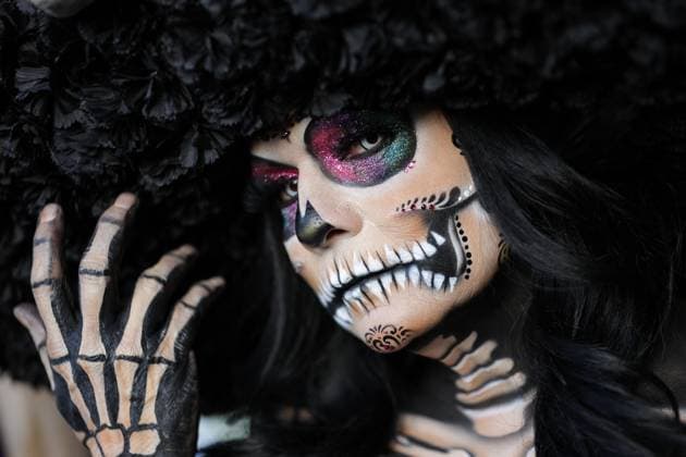 (251028) -- BEIJING, Oct. 28, 2025 -- A participant with facial makeup takes part in the Catrinas Parade in Mexico City, capital of Mexico, on Oct. 26, 2025. The Catrinas Parade was held on Sunday ahead of the Day of the Dead. (Photo by Xinhua) XINHUA PHOTOS OF THE DAY FranciscoxCanedo 