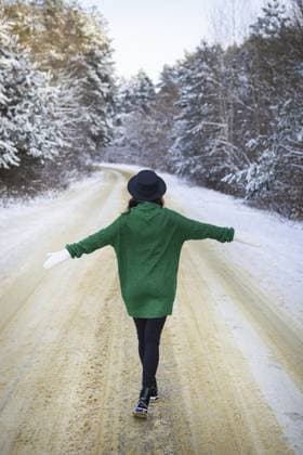 Ein junges Mädchen in grünem Pullover und Hut geht mitten auf einer verschneiten Straße in einem dichten Pinienwald spazieren. Eiskalter Tag A young girl in a green sweater and hat walks in the middle of a snowy road in a thick pine forest. Freezing day Copyright: imageBROKER SergiyxArtsaba ibxiqx14688815.jpg ,model released, Symbolfoto ,property released