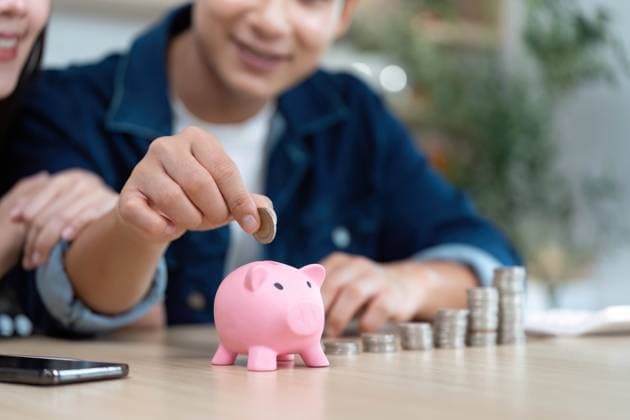 Ehepaar spart gemeinsam Geld. Junge Partner zahlen Münzen in ein Sparschwein ein. A couple joyfully saves money by depositing coins into a pink piggy bank, symbolizing shared financial goals. (License=RF) ,model released, Symbolfoto Copyright: xZoonar.com WICHAYADAxSUWANNACHUNx 23737748 ,model released, Symbolfoto ,property released