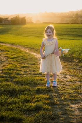 Little girl smiling and holding a windmill, sunset Corby, England, United Kingdom R_ATMT25052726-1739119-01 ,model released, Symbolfoto