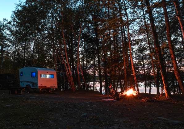 RV Camper on shore of lake with campfire at dusk, Maine The Forks, Maine, United States CR_SSNF2511012D-1872080-01 ,model released, Symbolfoto