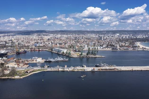 Lebendige Hafenstadt mit einem geschäftigen Hafen, unter einem strahlend blauen Himmel mit flauschigen Wolken. Luftaufnahme eines großen Frachtschiffs im Hafen von Burgas, Bulgarien. Logistik und Transport Vibrant harbor city with a busy port, under a bright blue sky with fluffy clouds. Aerial view of a big cargo ship on port of Burgas, Bulgaria. Logistics and transport Copyright: imageBROKER NikolaxSpasov ibxnsp15457349.jpg