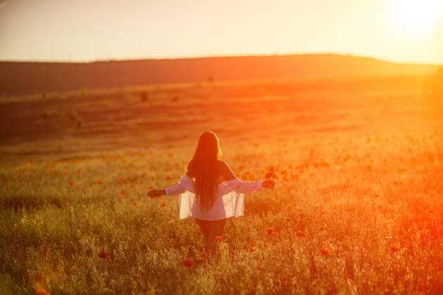 A woman is standing in a field of flowers, with the sun shining brightly on her. Concept of peace and tranquility, as the woman is enjoying the beauty of nature. A woman is standing in a field of flowers, with the sun shining brightly on her. Concept of peace and tranquility, as the woman is enjoying the beauty of nature, model released, , 59340660.jpg RECORD DATE NOT STATED