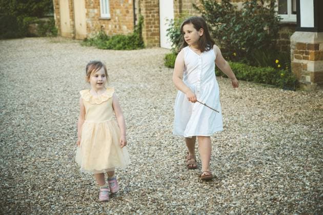 Two little girls walking together in old english village Corby, England, United Kingdom R_ATMT250528F1-1745500-01 ,model released, Symbolfoto