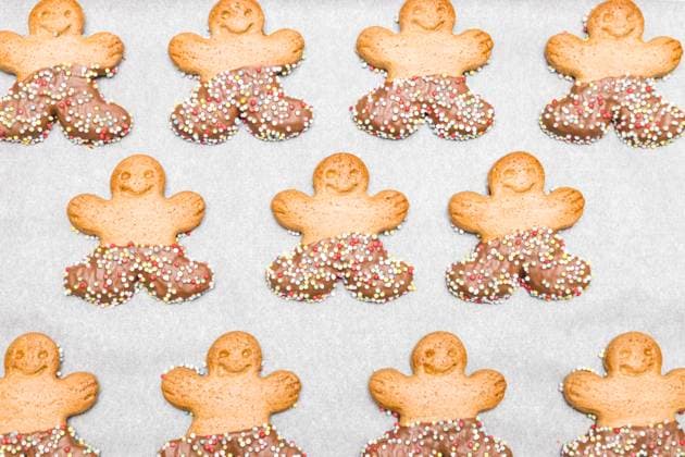 IMAGO Creative, Weihnachten, Food, Backen, Lebkuchen Three rows of gingerbread men on white baking paper. Three rows of gingerbread men on white baking paper in a baking dish, top view close-up. Holiday food concept., 61430622.jpg RECORD DATE NOT STATED