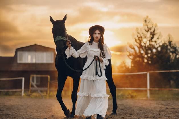 Frau in weißem Kleid und schwarzem Hut mit ihrem Pferd bei Sonnenuntergang im Freien auf der Ranch Woman in white dress and black hat with her horse at sunset outdoors ranch Copyright: imageBROKER Maxx4e ibxiqx15482739.jpg ,model released, Symbolfoto ,property released