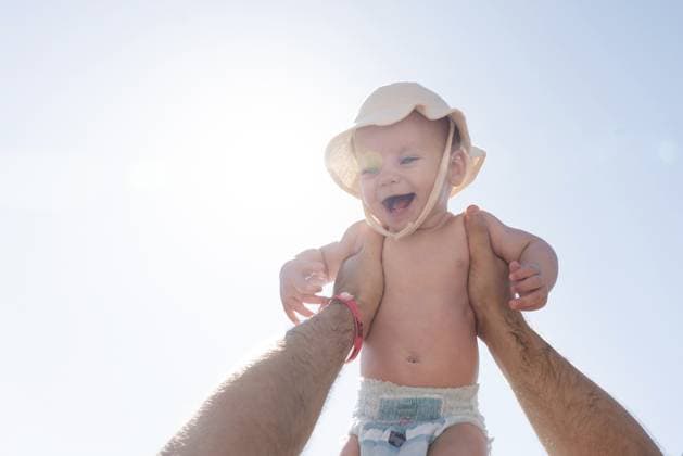 Halten Sie einen zärtlichen Moment fest, in dem ein Vater sein Baby hoch in die Luft hält und das Sonnenlicht eine warme Kulisse bildet. Konzept von Kindheitsfreude und väterlicher Verbundenheit Capturing a tender moment as a father holds his baby high in the air, the sunlight creating a warm backdrop. Concept of childhood joy and fatherly bond Copyright: imageBROKER MariaxKraynova ibxiqx15505460.jpg ,model released, Symbolfoto ,property released