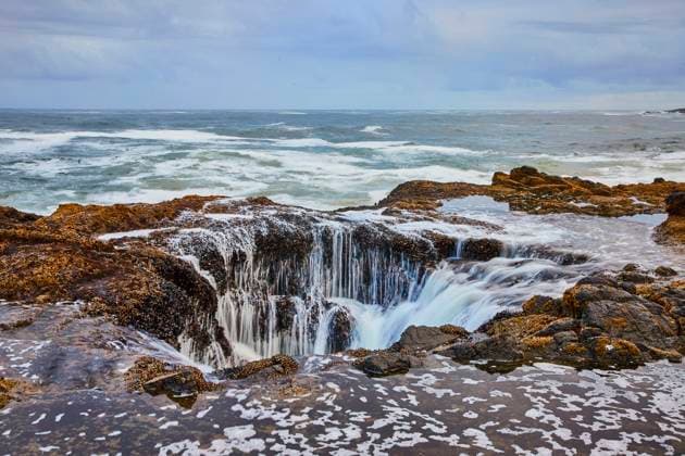Thor s Well Coastal Waves and Rock Pool from Elevated Perspective Experience the raw power of nature at Thor s Well, Oregon. Waves crash over barnacle-covered rocks, creating a natural waterfall effect against a dramatic, stormy sky. Perfect for travel and nature visuals., 60924516.jpg RECORD DATE NOT STATED