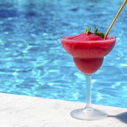 Ein lebendiger Erdbeer Daiquiri an einem erfrischenden Pool an einem sonnigen Tag, der ein Gefühl von Entspannung und tropischer Flucht hervorruft A vibrant strawberry daiquiri by a refreshing pool on a sunny day, evoking a sense of relaxation and tropical escape Copyright: imageBROKER MariaxKraynova ibxiqx15509356.jpg