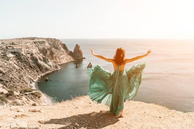 Woman green dress sea. Female dancer posing on a rocky outcrop high above the sea. Girl on the nature on blue sky background. Fashion photo. Woman green dress sea. Female dancer posing on a rocky outcrop high above the sea. Girl on the nature on blue sky background. Fashion photo, model released, , 61782316.jpg RECORD DATE NOT STATED