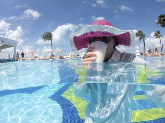 Frau mit Hut steht im Pool und trinkt Cocktail. Konzept eines schönen Urlaubs Woman wearing hat staning in pool drinking cocktail. Concept of happy vacation Copyright: imageBROKER MariaxKraynova ibxiqx15506693.jpg ,model released, Symbolfoto ,property released