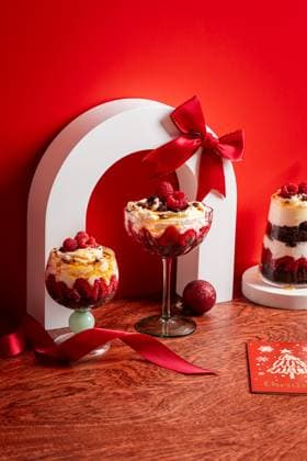 Christmas brownie trifle dessert with raspberries Festive Christmas trifle dessert with layers of fudge brownies, whipped cream, and fresh raspberries, elegantly displayed in glassware against a vibrant red backdrop. Model Released CintiaViudez_ID32747_1114985_013 Copyright: xCintiaxViudezx RECORD DATE NOT STATED