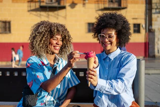 MR_ID32192_23578_NatachaBejaranoBonillo.jpg, MR_ID32192_23201_JavelinIsailisPereyraSierra.jpg Two friends enjoy a joyful afternoon in downtown, sharing a colorful ice cream cone. Their laughter and happiness highlight the lively city atmosphere under the sun. Model Released FotosAlberto_ID32192_1096014_022 Copyright: xFotosxAlbertox