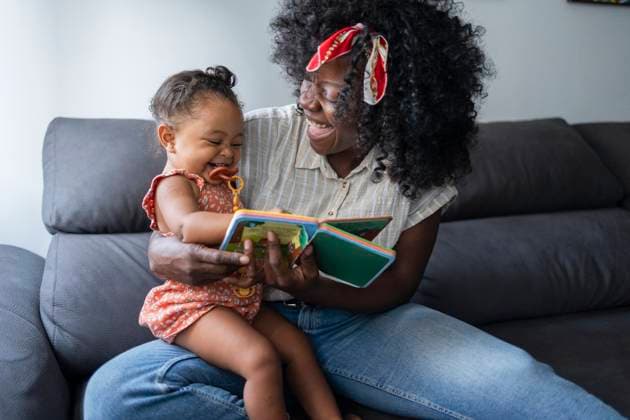 MR_ID32161_23183_AfricaBasco.jpg, MR_ID32161_23184_MariaDeLosAngelesJhones.jpg A joyful African American mother sits on a comfy sofa with her young daughter, enjoying quality time. They look at a book together, sharing smiles and laughter in their home. Model Released JoseCarlosIchiro_ID32161_1095066_006 Copyright: xJosexCarlosxIchirox RECORD DATE NOT STATED