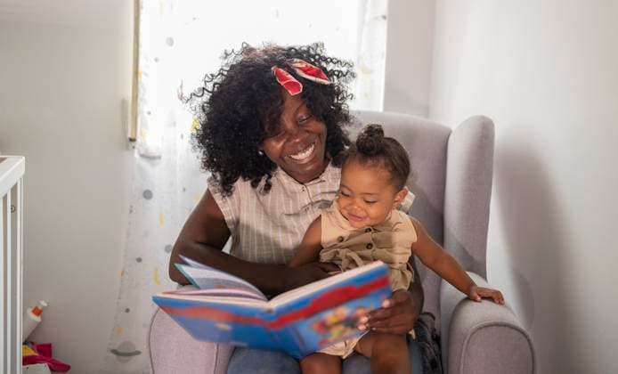 MR_ID32161_23183_AfricaBasco.jpg, MR_ID32161_23184_MariaDeLosAngelesJhones.jpg African American mother and daughter sitting together at home, bonding over a colorful picture book. The scene captures a joyful moment of learning and connection. Model Released JoseCarlosIchiro_ID32161_1095096_024 Copyright: xJosexCarlosxIchirox RECORD DATE NOT STATED