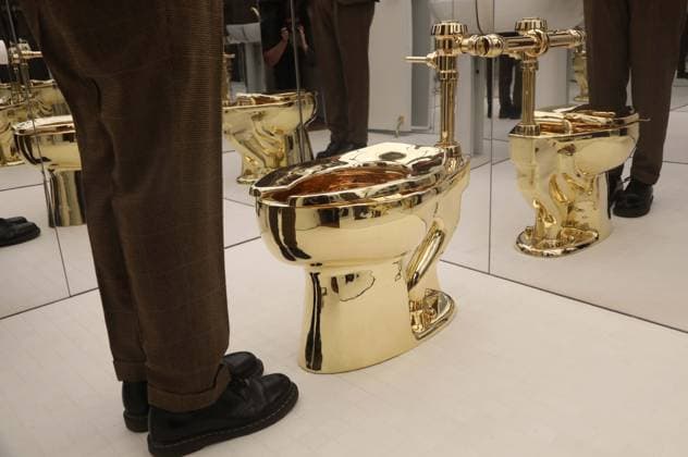 November 7, 2025, New York, New York, USA: A man examines Maurizio CattelanÃ¢â‚¬â ¢s America (2016): a fully functional toilet made from just over 100 kilograms of solid 18-karat gold, estimate starting at $10 million, seen on display during November Marquee Week 2025 during SothebyÃ¢â‚¬â ¢s Opening of the New Global Headquarters at the Breuer. New York USA - ZUMAk03_ 20251107_zaf_k03_016 Copyright: xNancyxKaszermanx