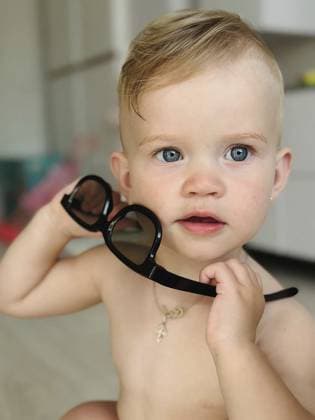 Baby mit schwarzer Sonnenbrille, das den Betrachter mit unschuldiger Neugier ansieht Baby holding black sunglasses, looking with innocent curiosity at the viewer Copyright: imageBROKER ???????x??????? ibxnfw15579849.jpg ,model released, Symbolfoto ,property released