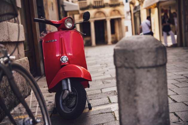 Classic red vespa scooter parked on a cobblestone street in padua, italy Padova, italy 30 june 2025, vibrant red vespa scooter parked on a charming cobblestone street in padua, italy, capturing timeless style and italian charm, 98086492.jpg RECORD DATE NOT STATED