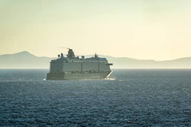 Mykonos, Kykladen, Griechenland - Kreuzfahrtschiff MEIN SCHIFF 5 faehrt aus der Hafenbucht Mykonos und hinterlaesst eine dunkle Abgaswolke. Mykonos Mykonos Griechenland *** Mykonos, Cyclades, Greece Cruise ship MEIN SCHIFF 5 leaves the harbor bay of Mykonos and leaves behind a dark cloud of exhaust fumes Mykonos Mykonos Greece
