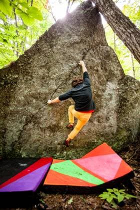 A rock climber climbs the face of a boulder with crash pads below United States, New Hampshire, Keene CR_VAWG251110-1874753-01 ,model released, Symbolfoto