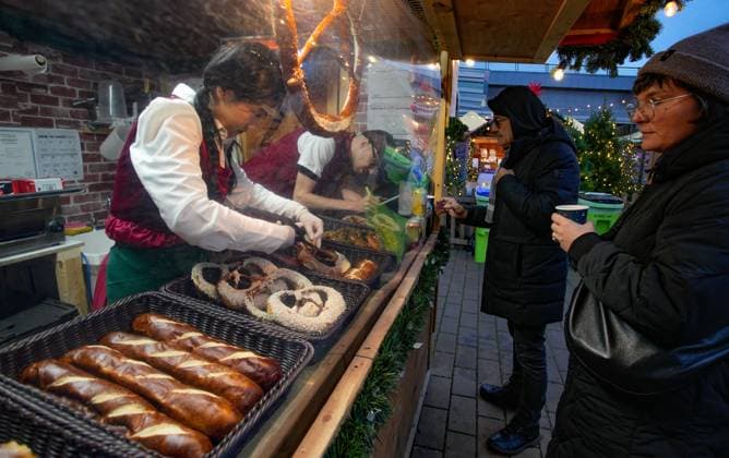(251115) -- VANCOUVER, Nov. 15, 2025 -- Vendors work at a wooden hut selling food at the Vancouver Christmas Market in Vancouver, British Columbia, Canada, Nov. 14, 2025. The annual festive event features more than 110 wooden huts offering various handicrafts, traditional European food, drink, and souvenirs, along with live performances. This year s market opened here on Thursday and will run until Dec. 24. (Photo by Xinhua) CANADA-VANCOUVER-CHRISTMAS MARKET LiangxSen
