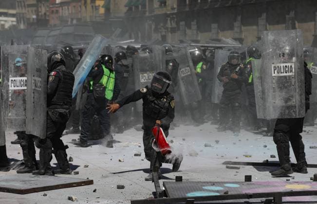 A police throws a stone against demonstrators during the Ã¢â‚¬ËœGen ZÃ¢â‚¬â ¢ demonstration at main square Zocalo against the Mexican government following the murder of Uruapan Mayor Carlos Manzola, while Mexico s President, Claudia Sheinbaum, has questioned the legitimacy of the movement in recent days . on November 15, 2025 in Mexico City, Mexico. Mexico City Mexico - ZUMAe321 20251115_zia_e321_093 Copyright: xIanxRoblesx