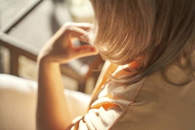 Kaukasische junge Erwachsene, die in einem sonnenbeschienenen Raum mit hellbraunen Haaren sitzt und ein orangefarbenes und beiges Hemd trägt Caucasian female young adult sitting in sunlit room with light brown hair, wearing orange and beige shirt Copyright: imageBROKER ElenaxSafonova ibxiqx15551258.jpg ,model released, Symbolfoto ,property released