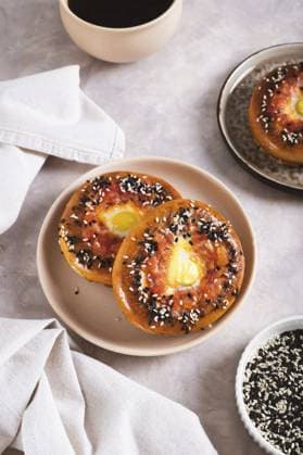 IMAGO Creative, Food, High Protein Frühstück Ei mit Tomaten und Sesamsamen, gebacken in Bagels auf einem Teller auf dem Tisch, vertikale Ansicht Egg with tomato and sesame seeds baked in bagels on a plate on the table vertical view Copyright: imageBROKER ElenaxRui ibxiqx15558415.jpg